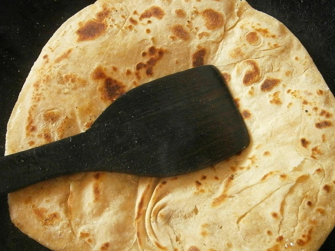 A plain roti and a layered paratha side by side on a tawa