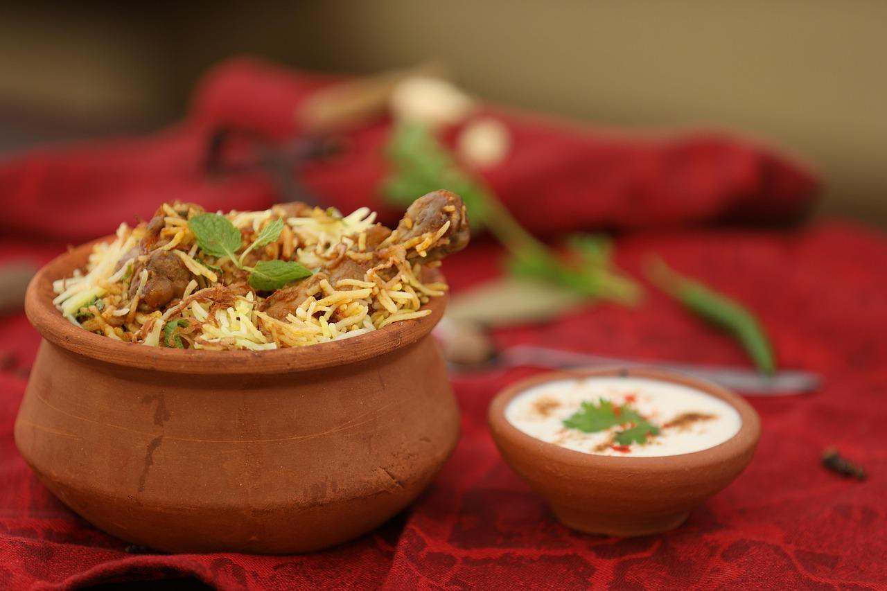 Plates of spicy Chicken Biryani and aromatic Mutton Yakhni Pulao served with cucumber raita