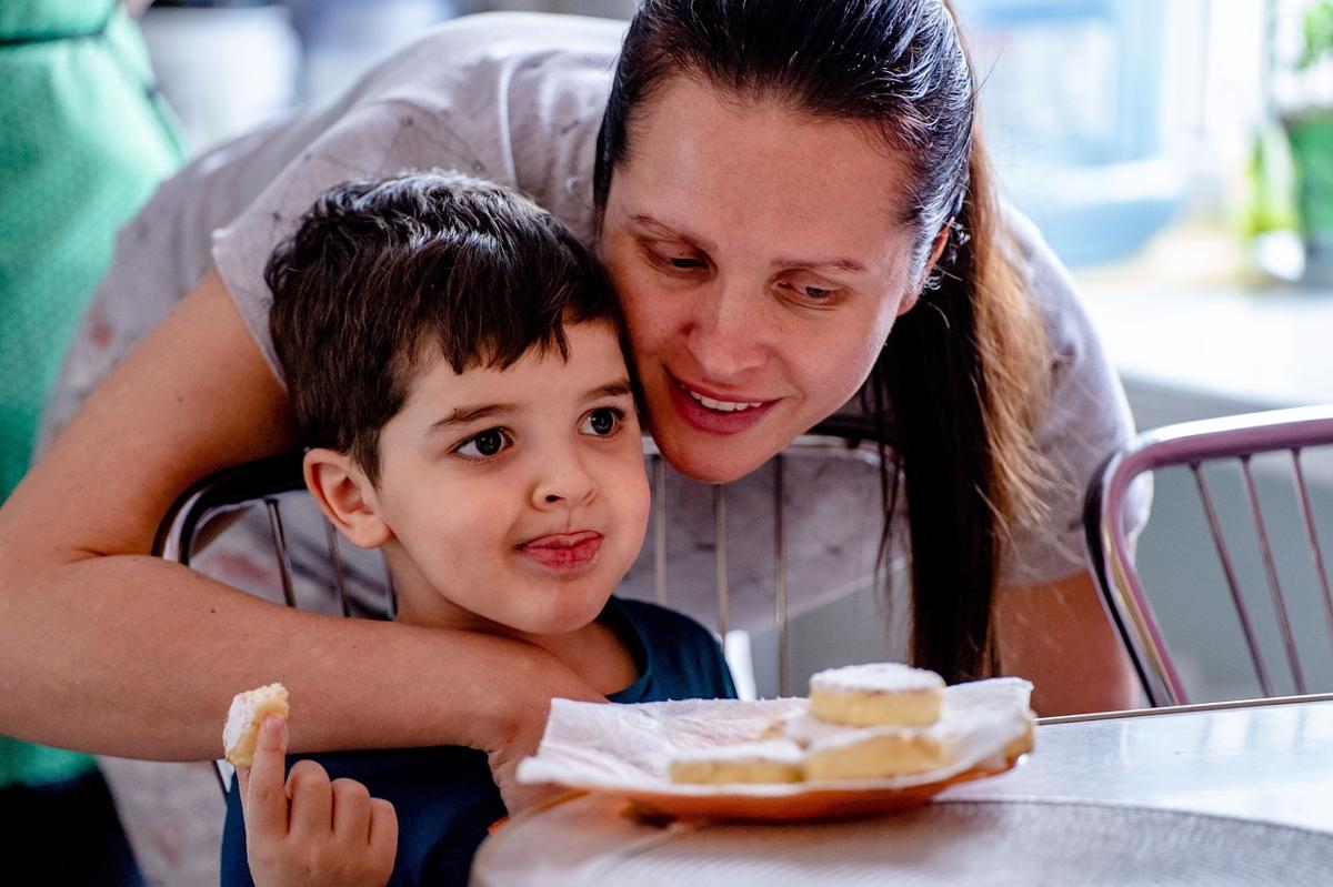 Parent holding glucometer explaining blood sugar testing gently to young child