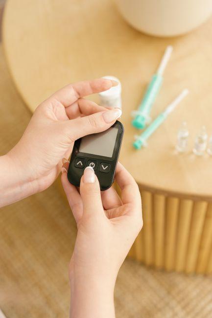 Hands holding a blood glucose meter ready for testing