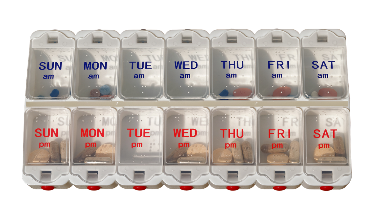 Pill organizer box on a table showing days of the week